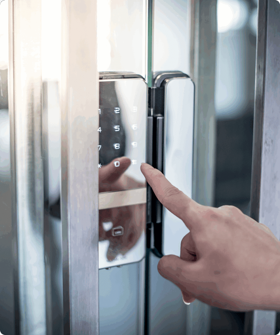 Finger pressing keypad on glass door lock.