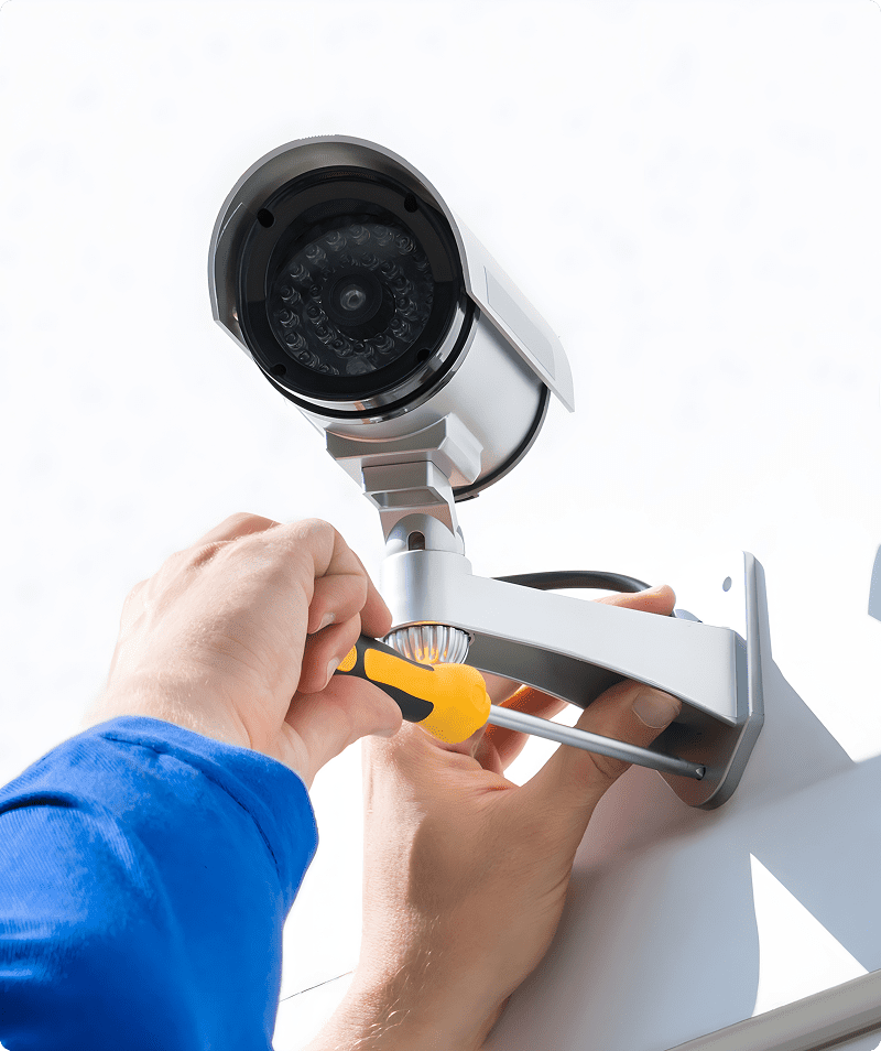 Installing a security camera with screwdriver.