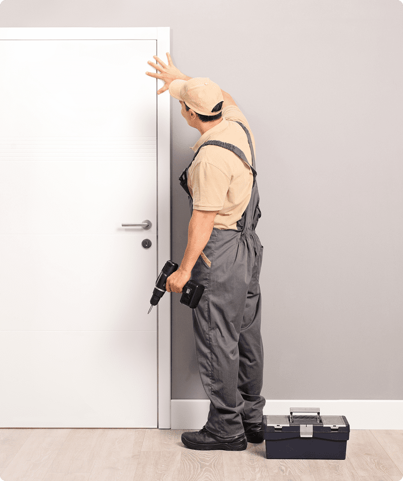 Worker fixing door with a drill.